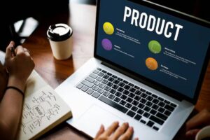 A laptop displays a product overview with sections on Marketing, Identity, Advertising, and Strategy, alongside a coffee cup and notebook.