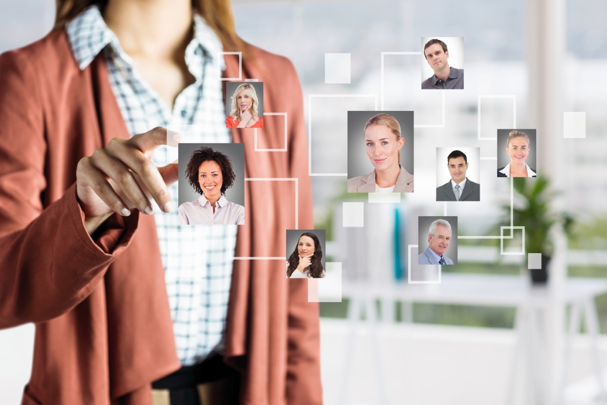 A person in a blazer interacts with a digital network of profile thumbnails linked by lines, suggesting a professional or social connection.